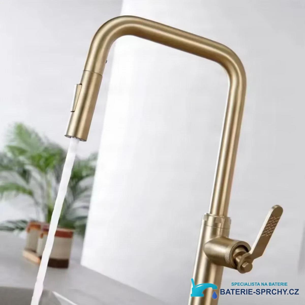 Moderní kuchyňská baterie ELITE EDITION KF1692 při použití: kartáčované zlato a proud vody